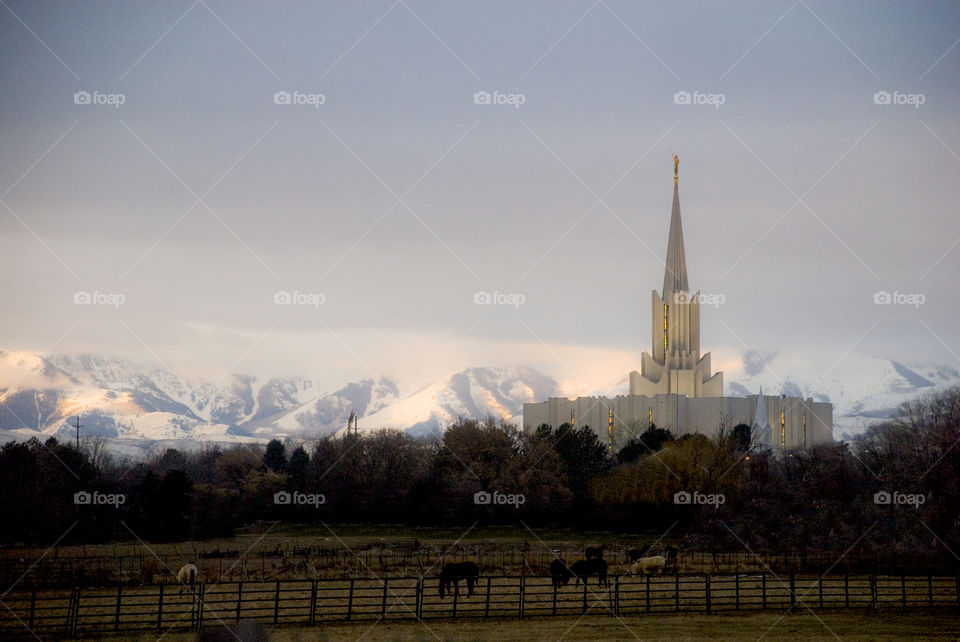 Jordan River LDS Temple in winter with snow capped mountains in the background