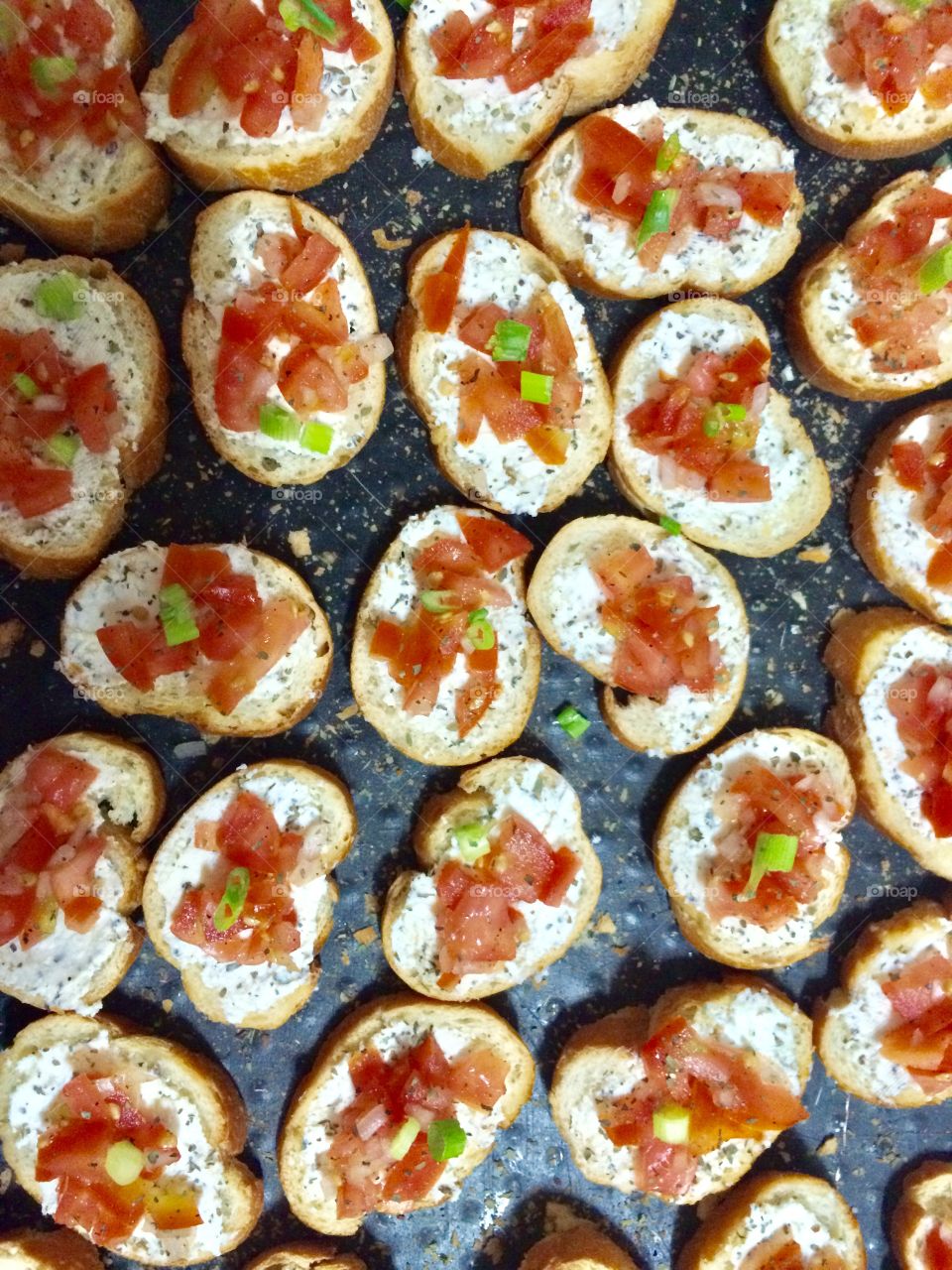 Bruchettas with tomato goat cheese olive oil green onions and herbs