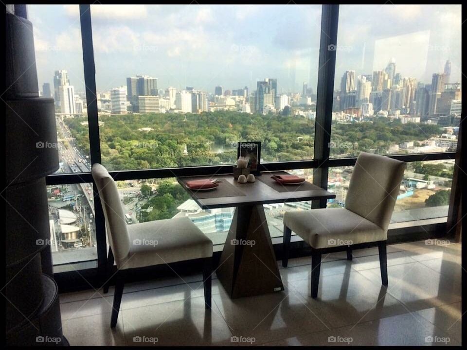 Table and chairs in front of window with city view.
