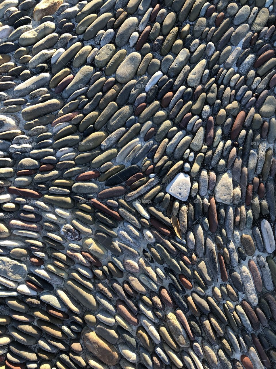 A sea of smooth rocks laid on their sides to create a pattern