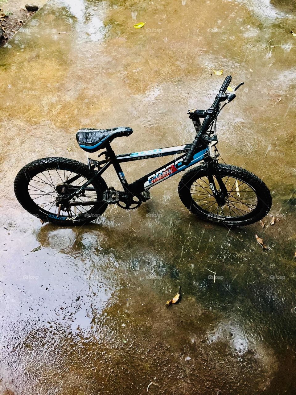 One lonely bicycle under the heavy rain 