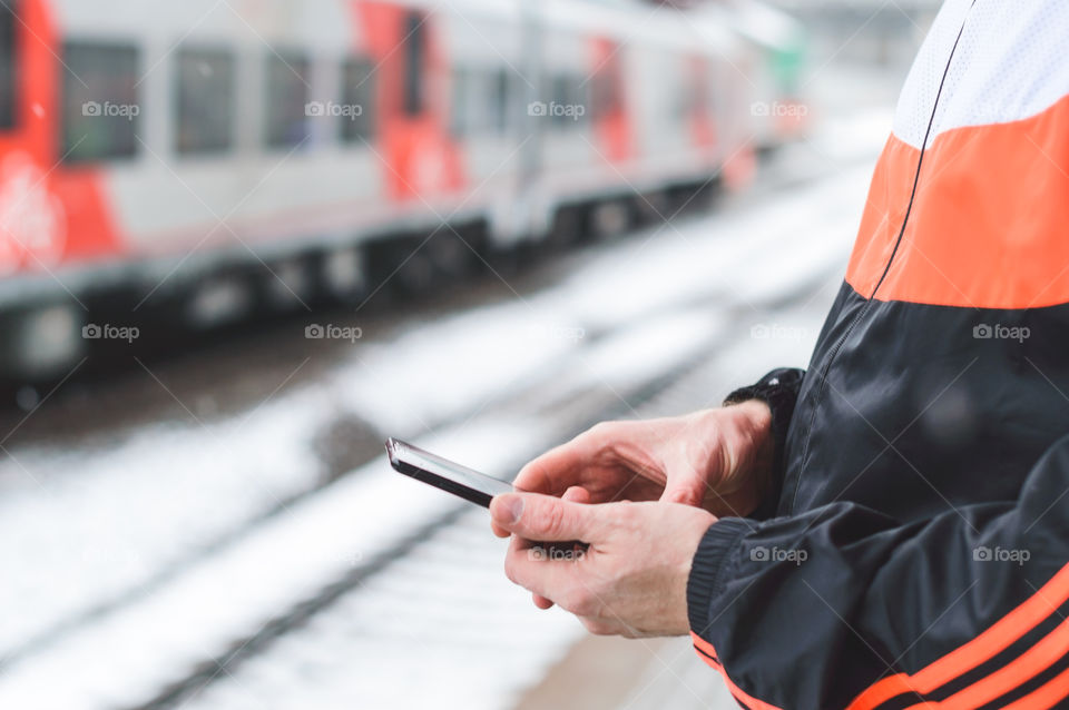 Man using smartphone on the train station