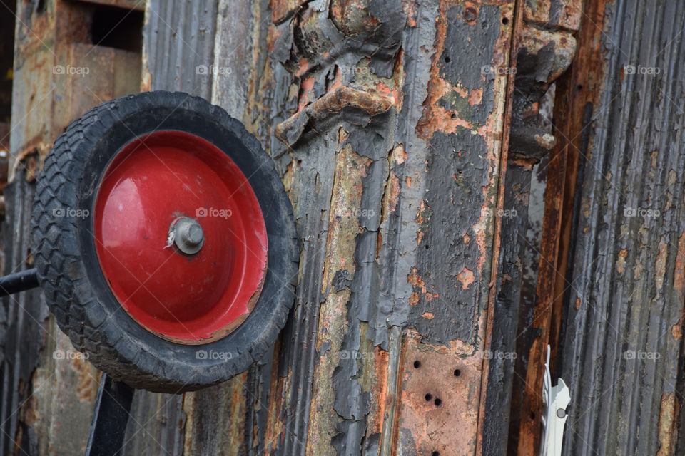 Red. Red color mission, color pop of red. Old wagon wheel in the junkyard