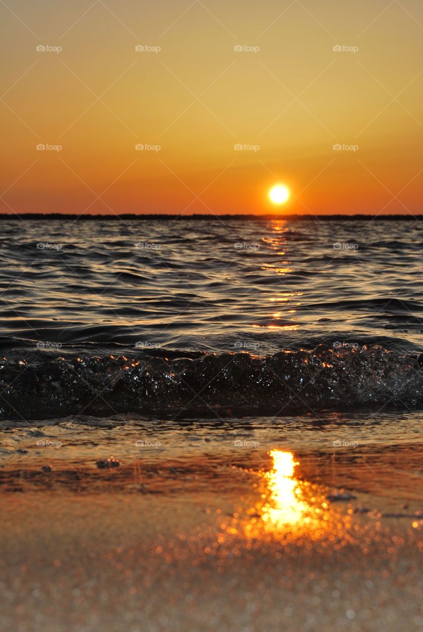 horizon features mild yellow atmosphere and dark ocean in beach view in sunrise