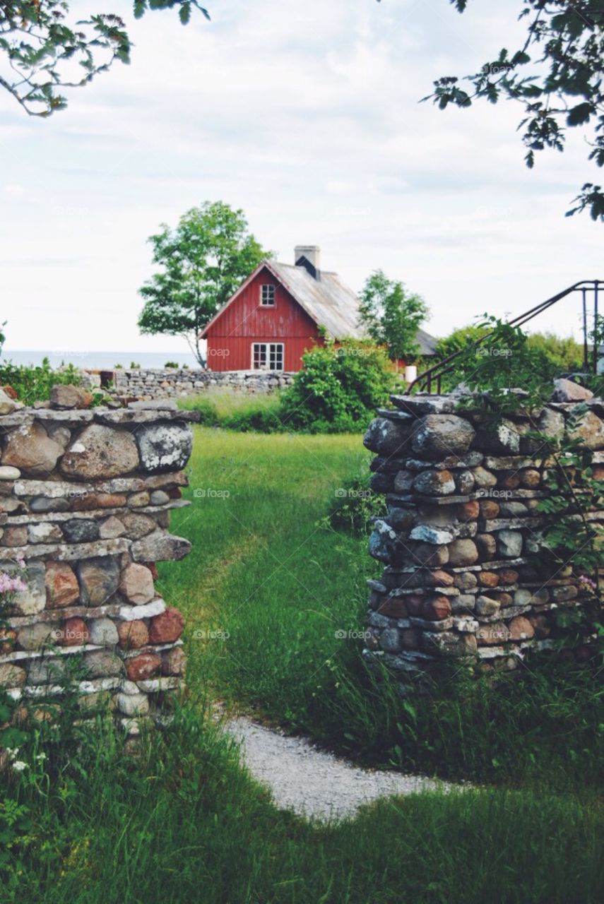 An old stone fence . An old stone fence and a red house