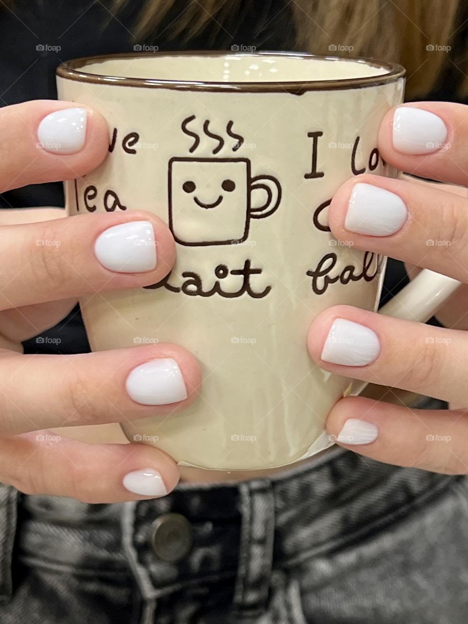 Beige cup of coffee in the hands of a girl