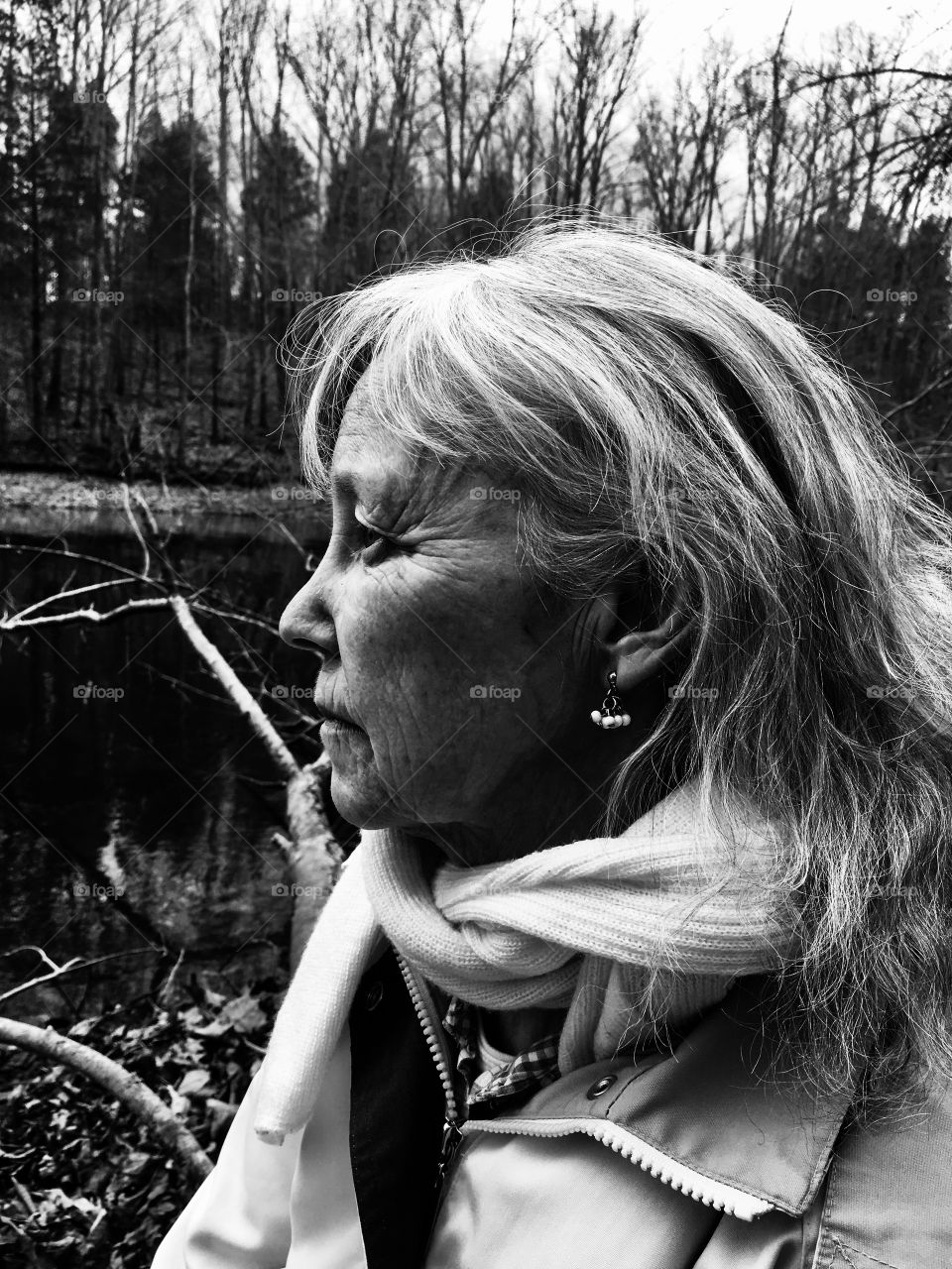 Black and white of a beautiful elderly lady in deep thought in the forest. Exudes wisdom and full of life experience. 