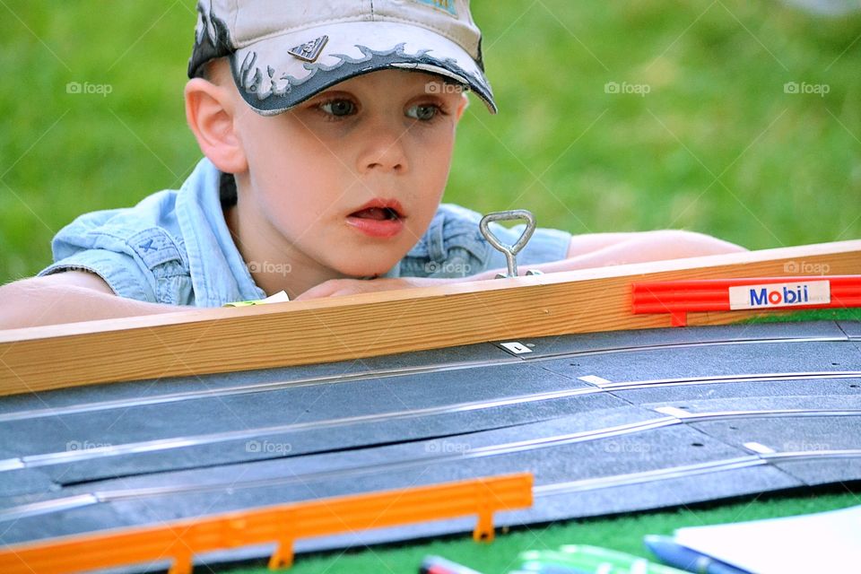 Boy . Boy watches the cars on a car track