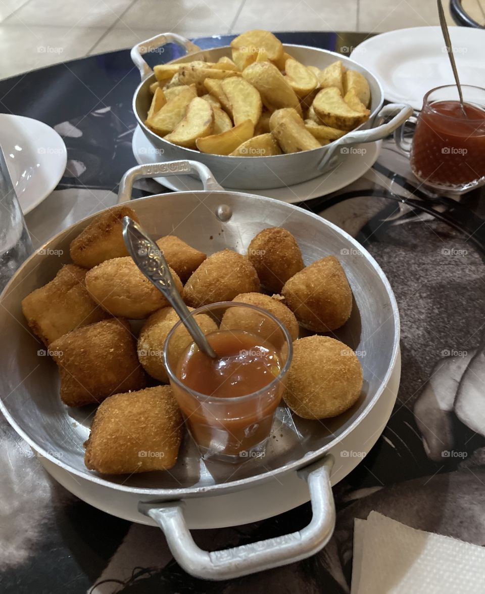 Salgados maravilhosos como petiscos: bolinhas de queijo, coxinhas de frango e trouxinhas de carne - acompanhados por batatas rústicas.