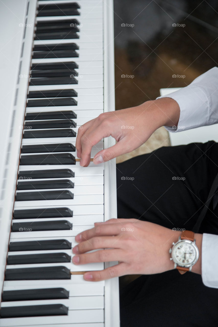 Working hands gently playing the piano
