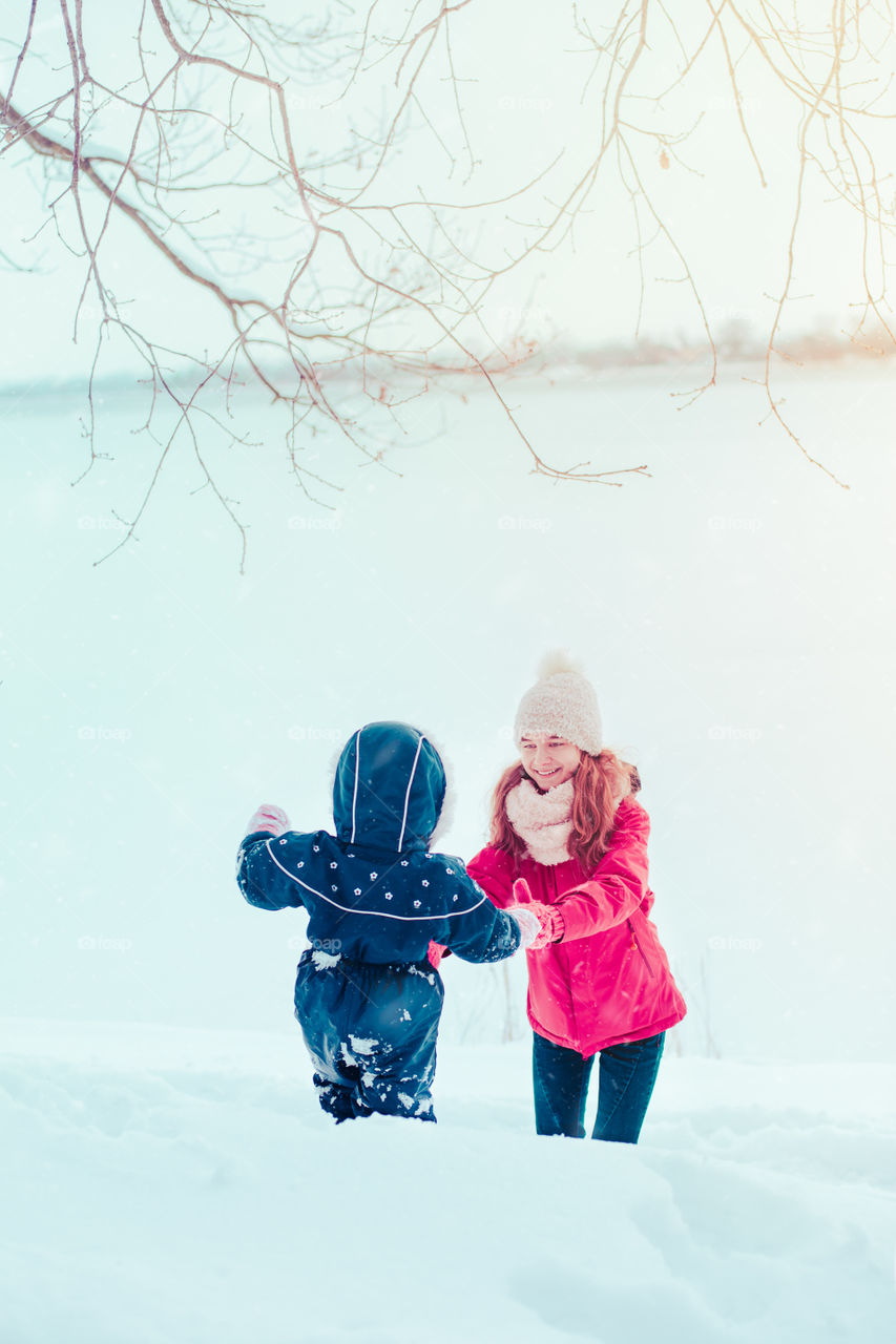 Teenage girl enjoying snow with her little sister enjoying wintertime