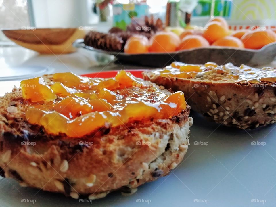 Homemade peach jam spread on whole grain dark rye bread