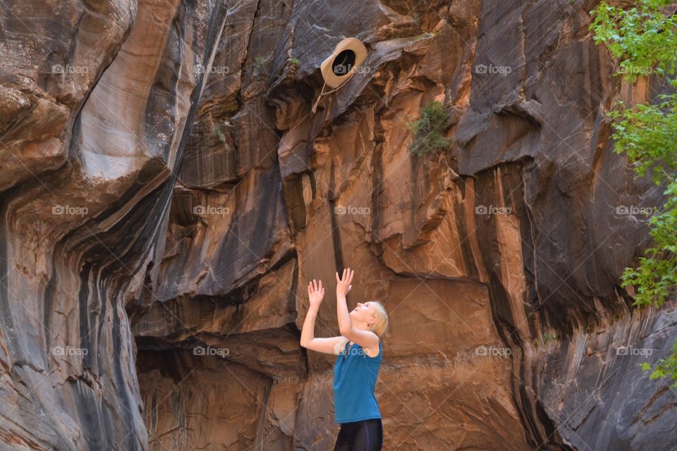 Women throws hat in the air in Zion Narrows