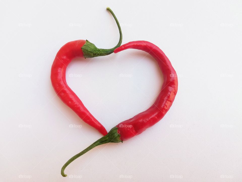 Two red chillies cross and form a heart