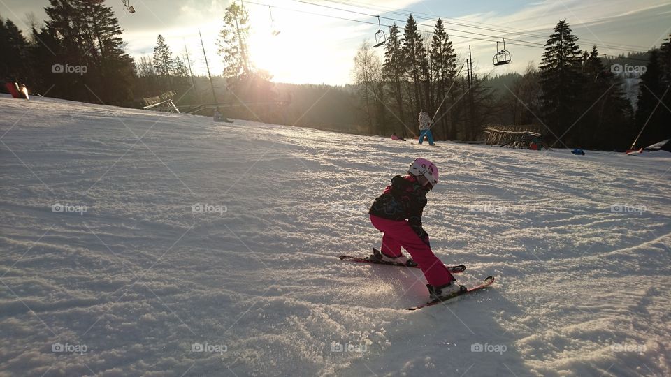 kid skiing in the sunset