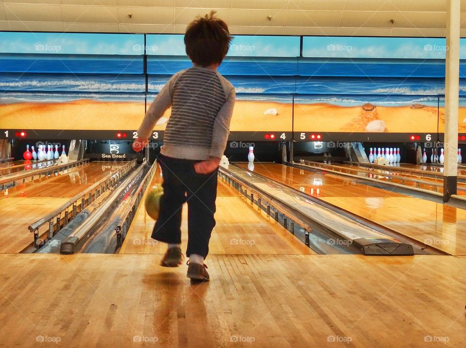 Little Boy Going Bowling. Young Boy At A Bowling Alley