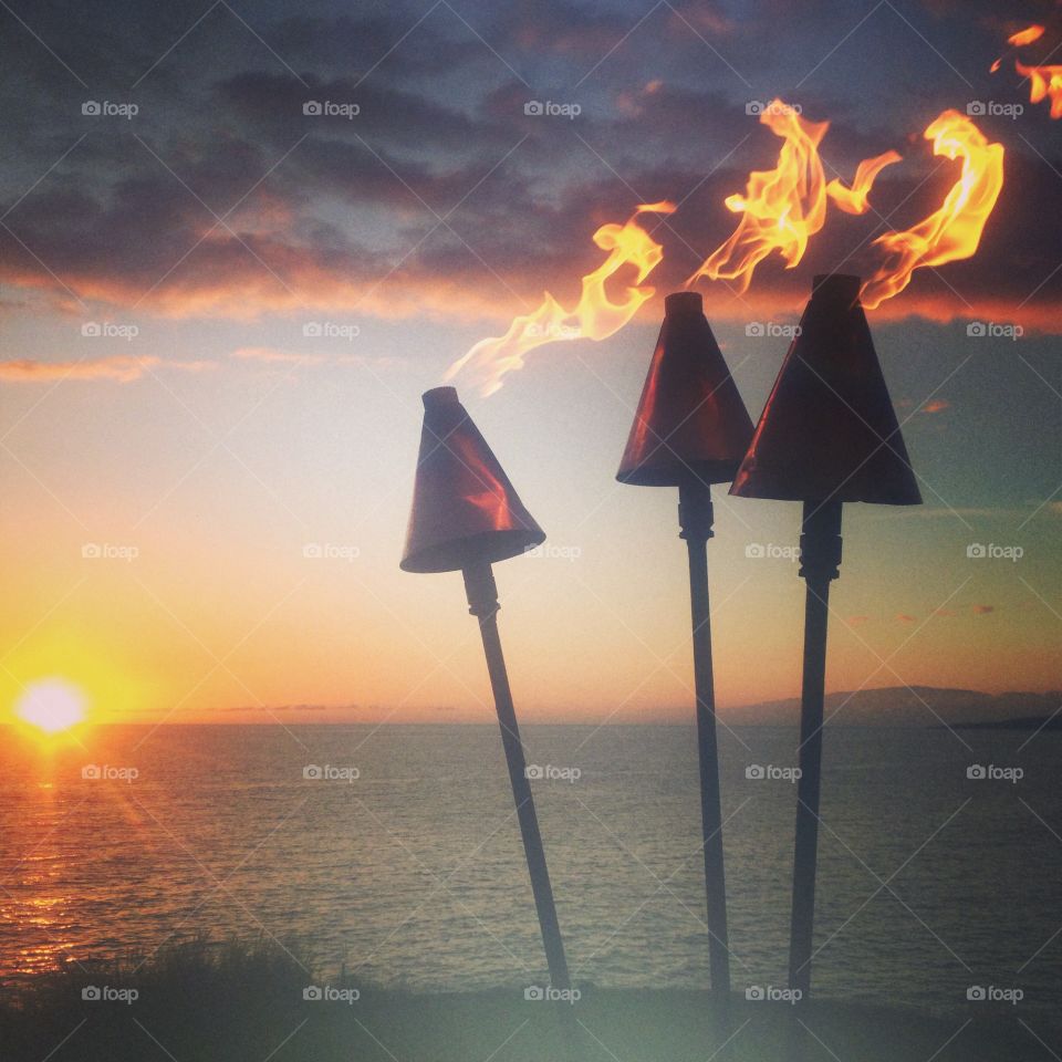 A Hawaiian sunset and tiki lit fire was a beautiful wedding backdrop 