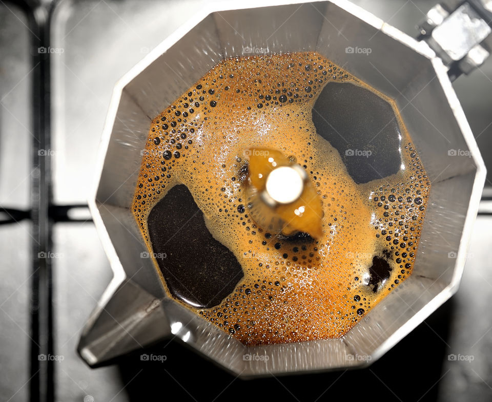 Coffee being made in an Italian coffee pot, top view.