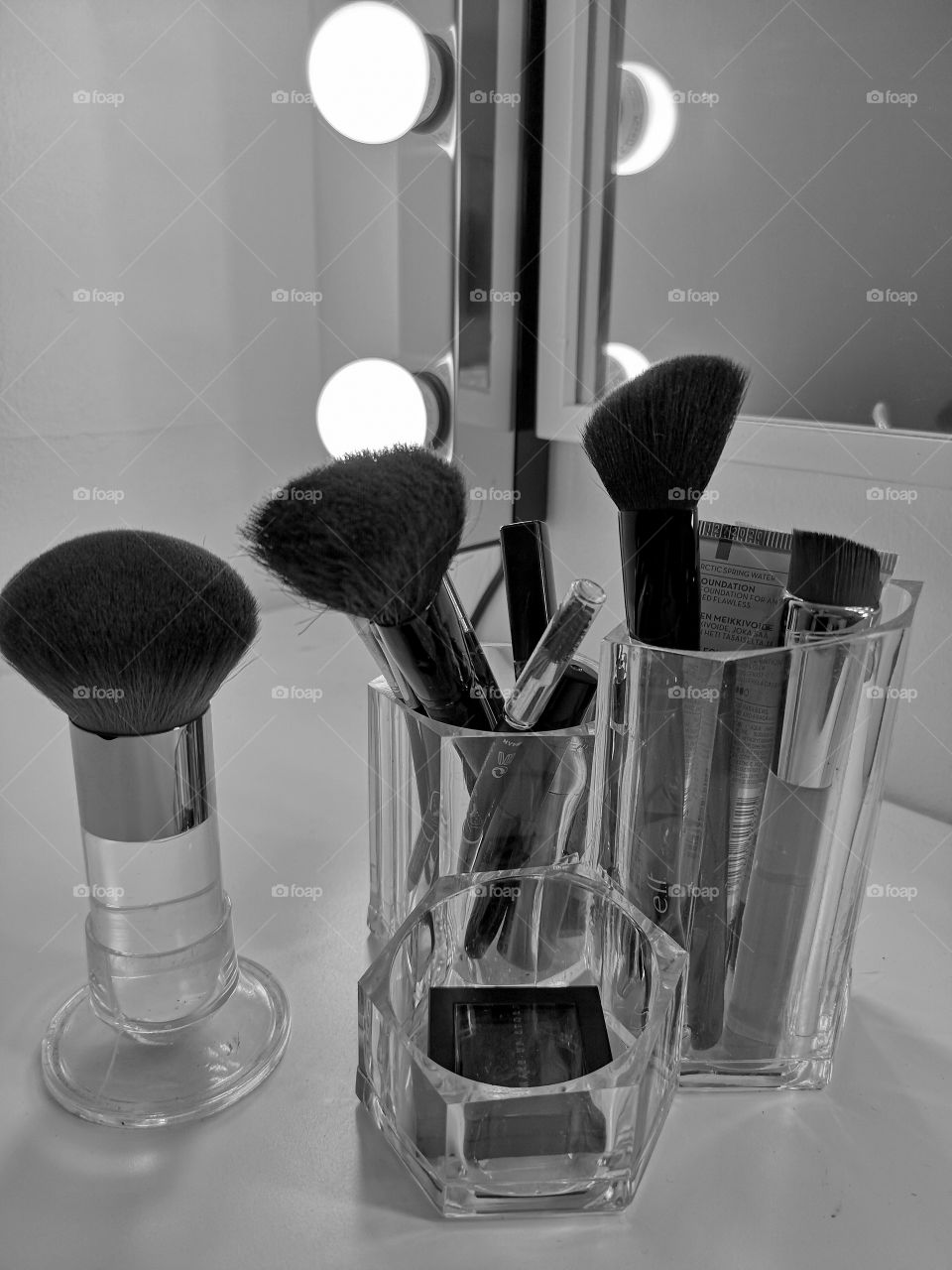 Make up brushes on a make up table and mirror with lights