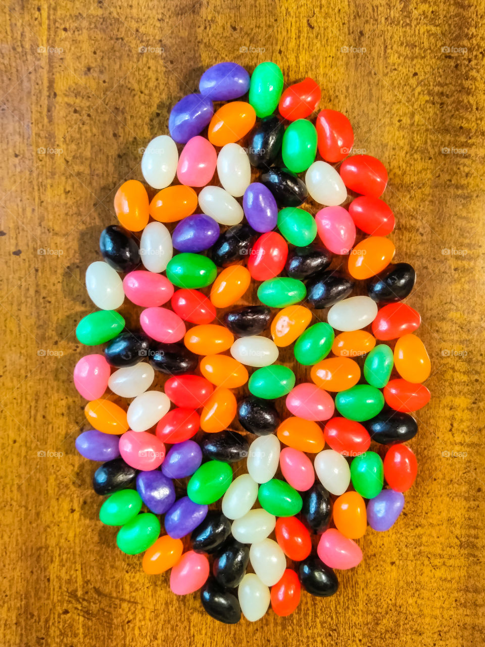 Colorful Jelly Beans Candies Shaped Like An Egg On Wood Table