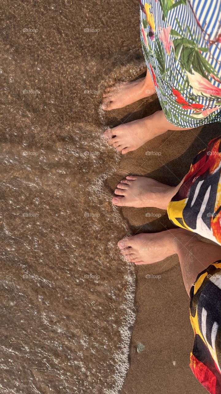 2 Pairs of legs steps on the sandy beach