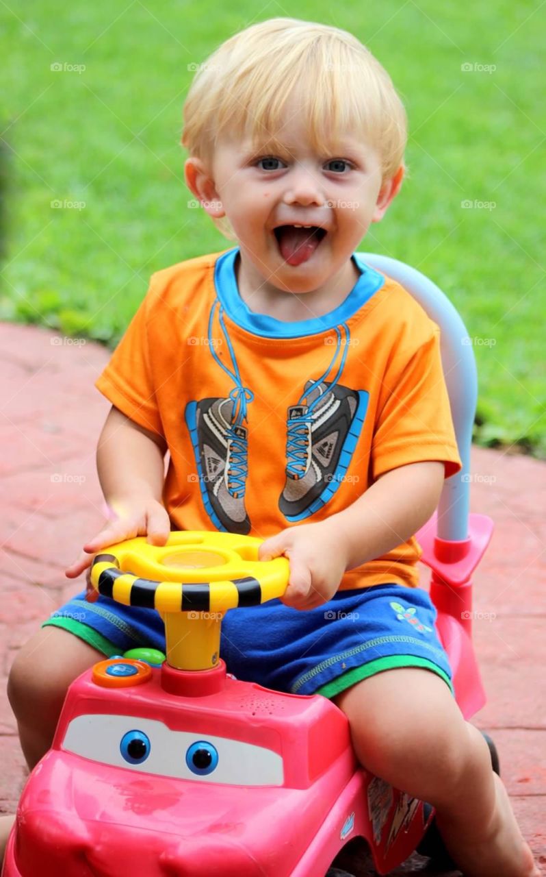 Little boy riding toy car