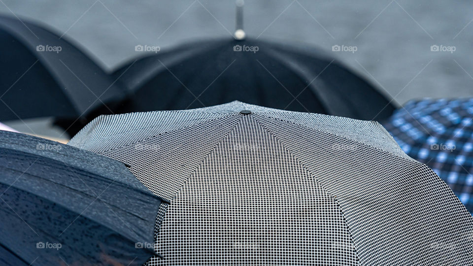 Busy street with crowd of people with umbrellas.