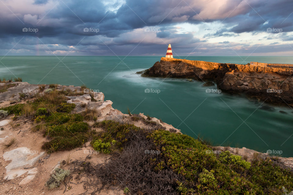 Cliff and Lighthouse at colourfull sunrise