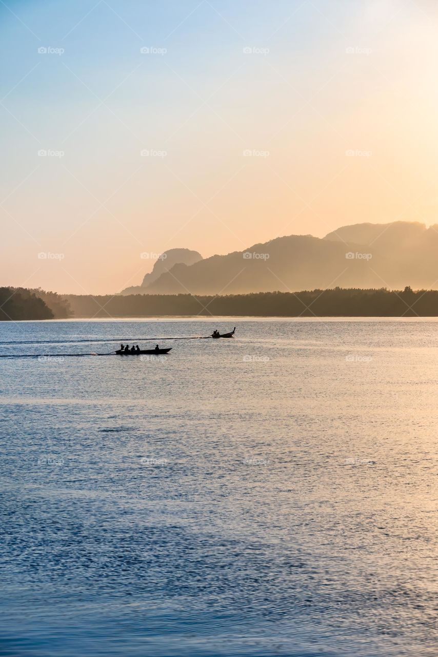 Beautiful Sunrise moment above silhouette of boat in sea