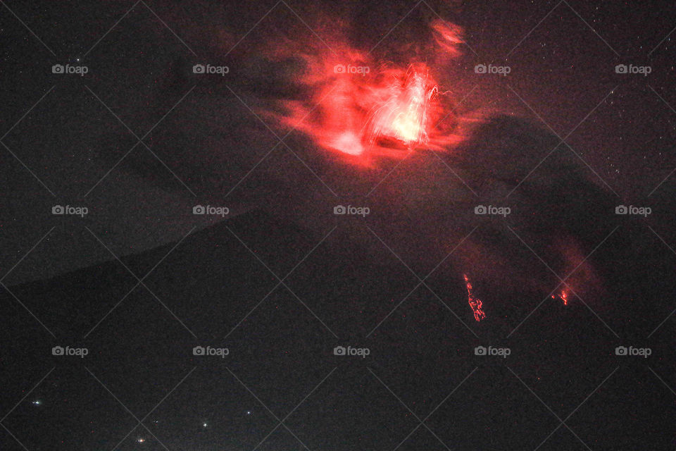 Mayon Volcano image while spewing lava and bouldrers at night. This looks like fireworks at nigh