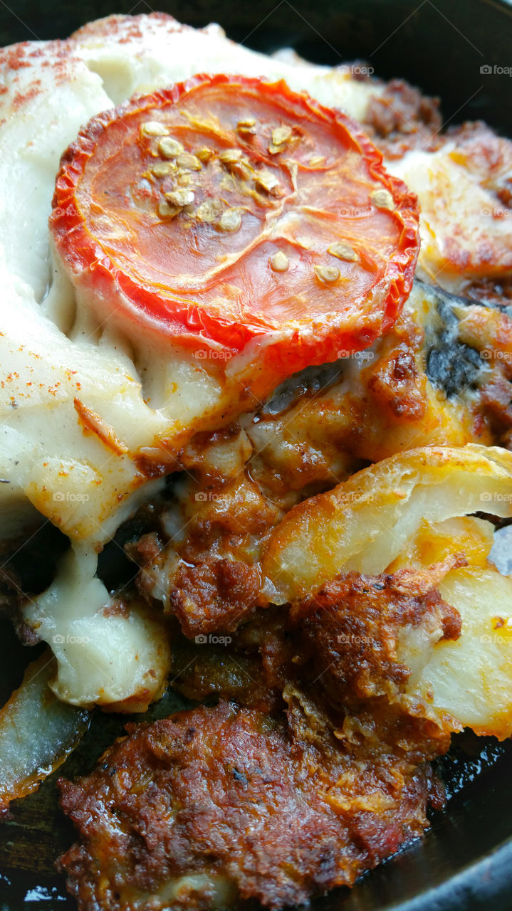 Close-up of baked moussaka with a tomato on top