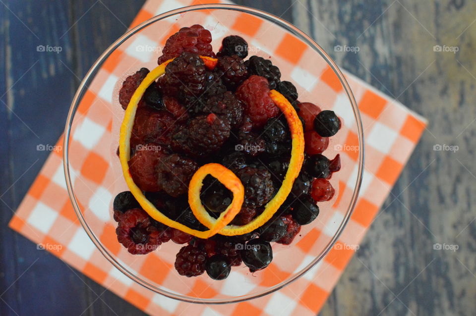 A glass of berries with orange