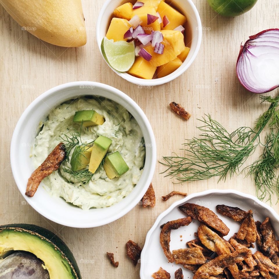 Healthy Mexican food  creamy avocado dip with spicy anchovies and mango.