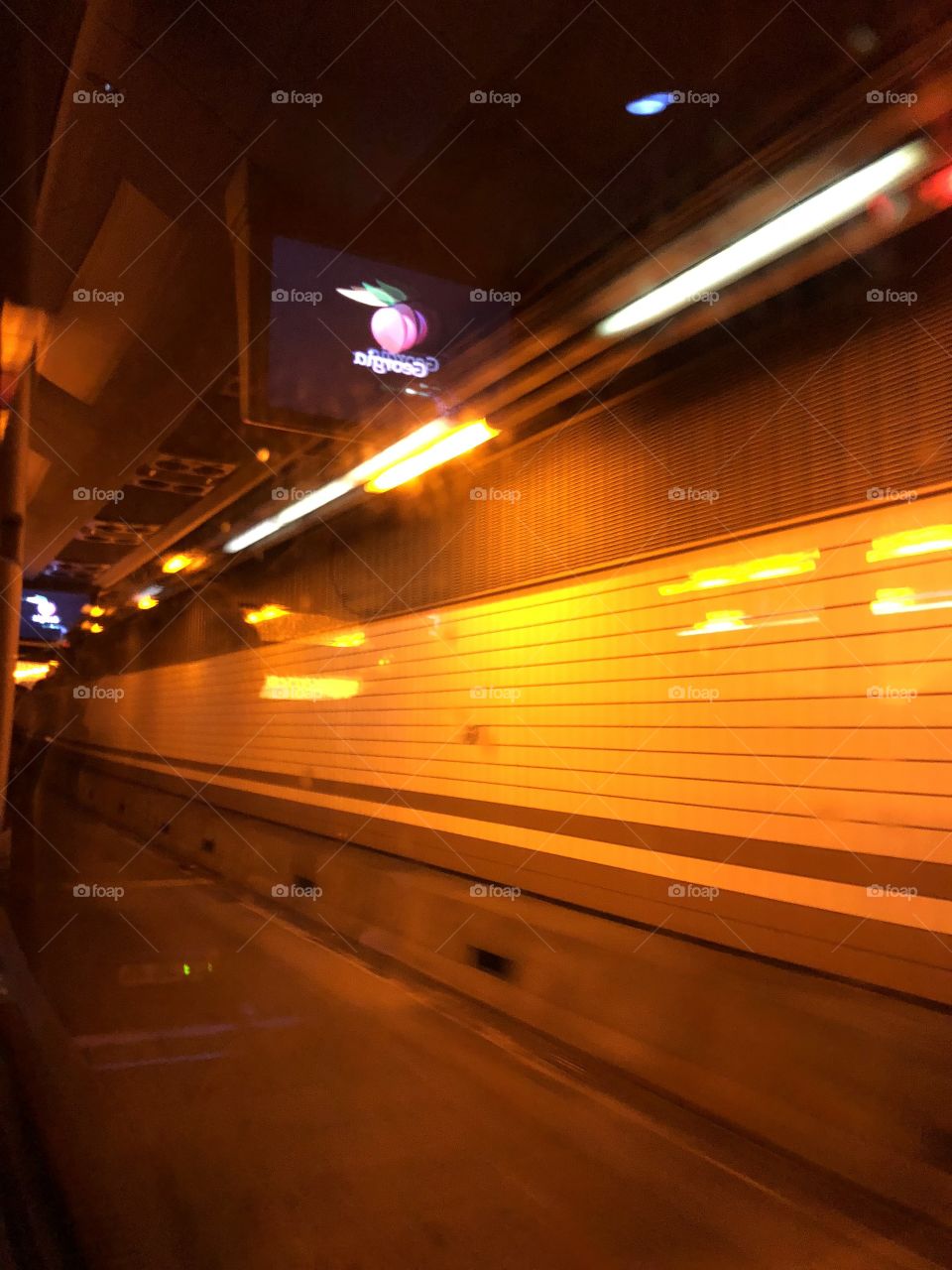 Traveling through a tunnel under the city streets of Boston, MA while looking out my window, riding as a passenger on a bus 