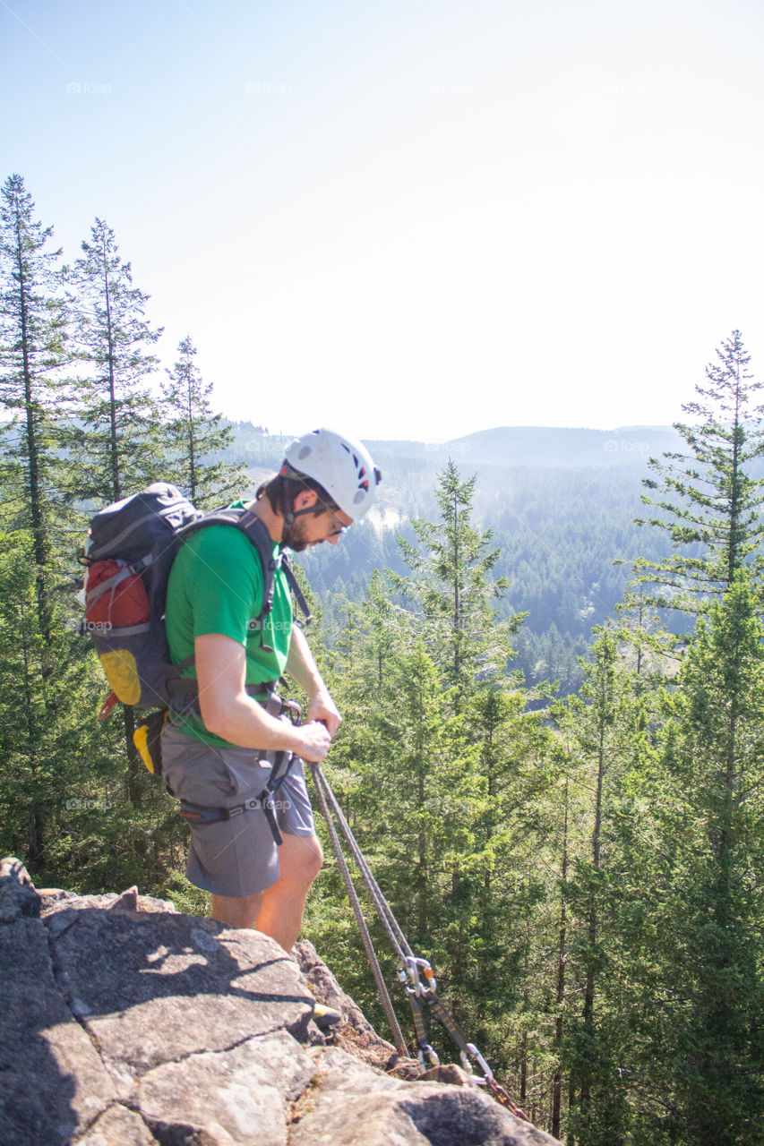 Ryan getting ready for rock climbing on a sunny day in the forest 