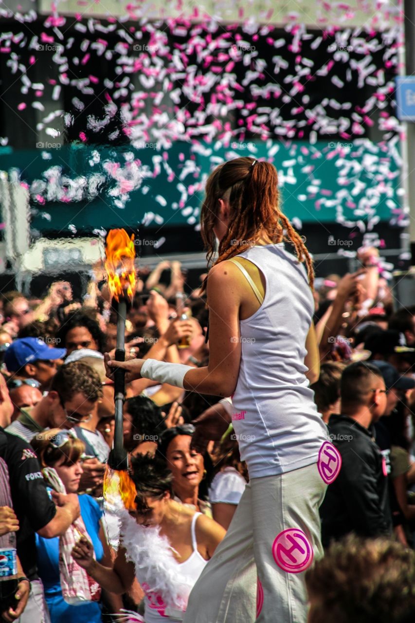 Red head entertainer playing with fire during a festival in the middle of a crowd