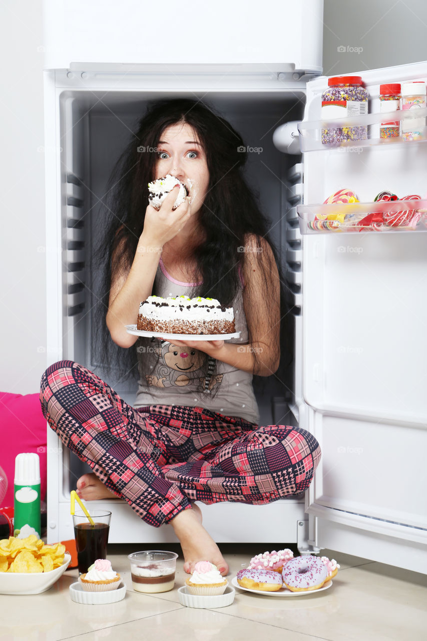 Funny girl eat sweet food in fridge