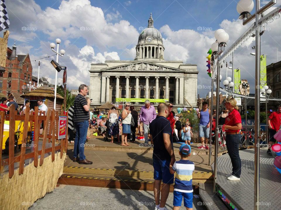 People enjoying good weather on the artificial beach in the Old Market Square with the Council House in the background, Nottingham, England, UK