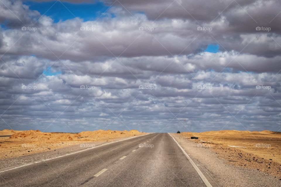 Cluldy day and long road in desert