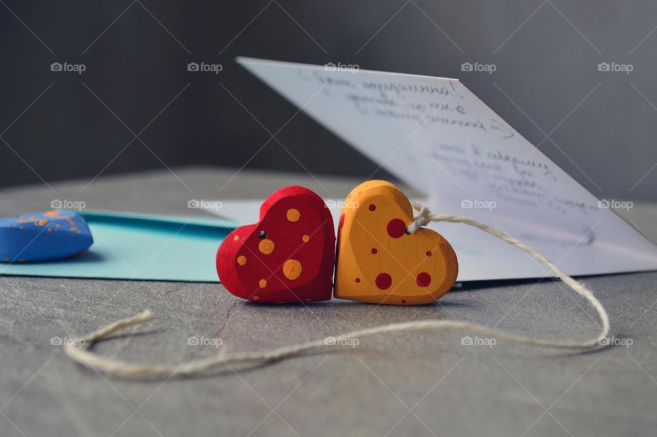 Multicolored wooden hearts near a greeting card