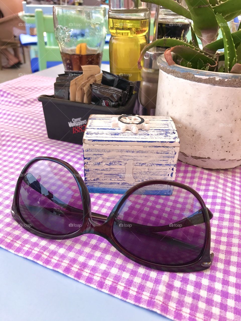 On this photo are sunglasses on a square tablecloth with sea details at the Montenegro seaside.