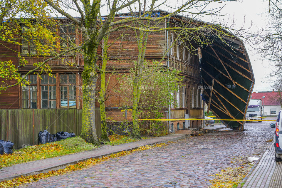 yellow police tape surrounds this building following a severe storm that lifted and removed a metal roof
