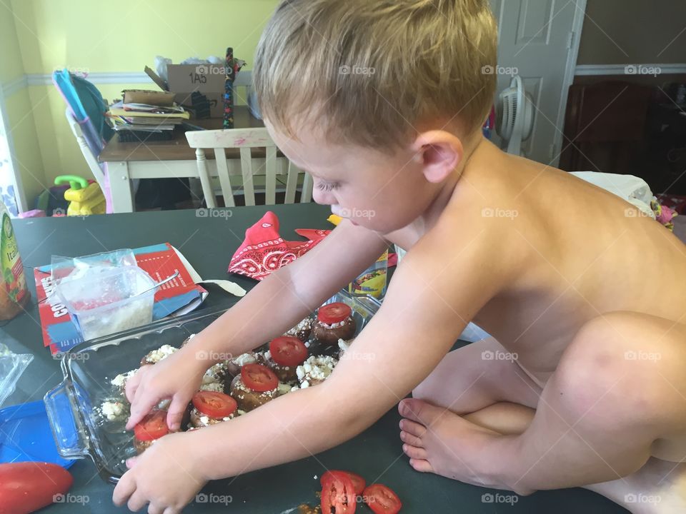 Cute child arranging dessert in plate