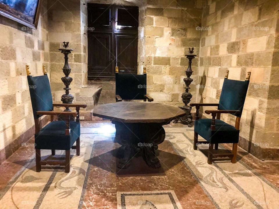 Furniture. blue chairs+table used in the past , display in a castle room , tiled with elaborate pattern