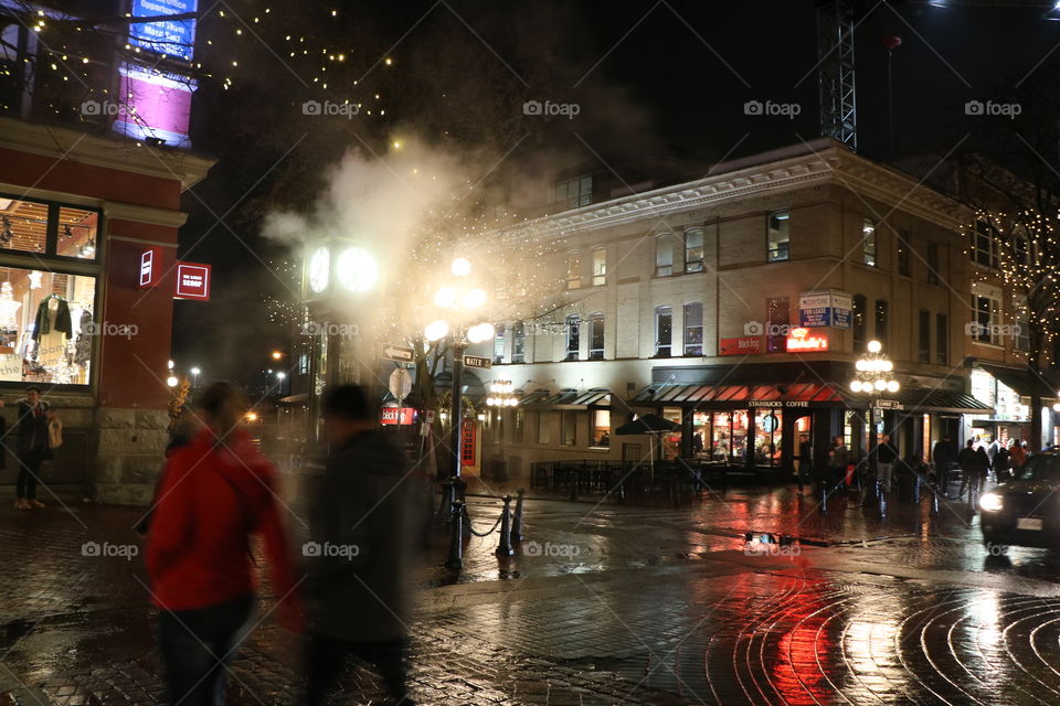 People walking , cars riding , clock steaming . The coziness of the night in the old town