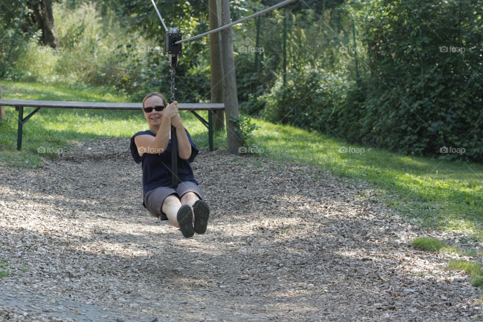 Zipline. Woman riding on zipline in adventure park