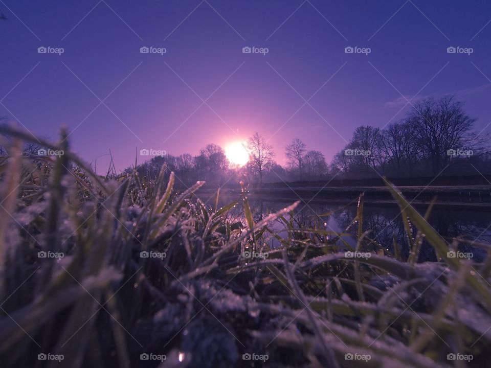 Countryside sunrise showing the colorful sky over the frozen grass