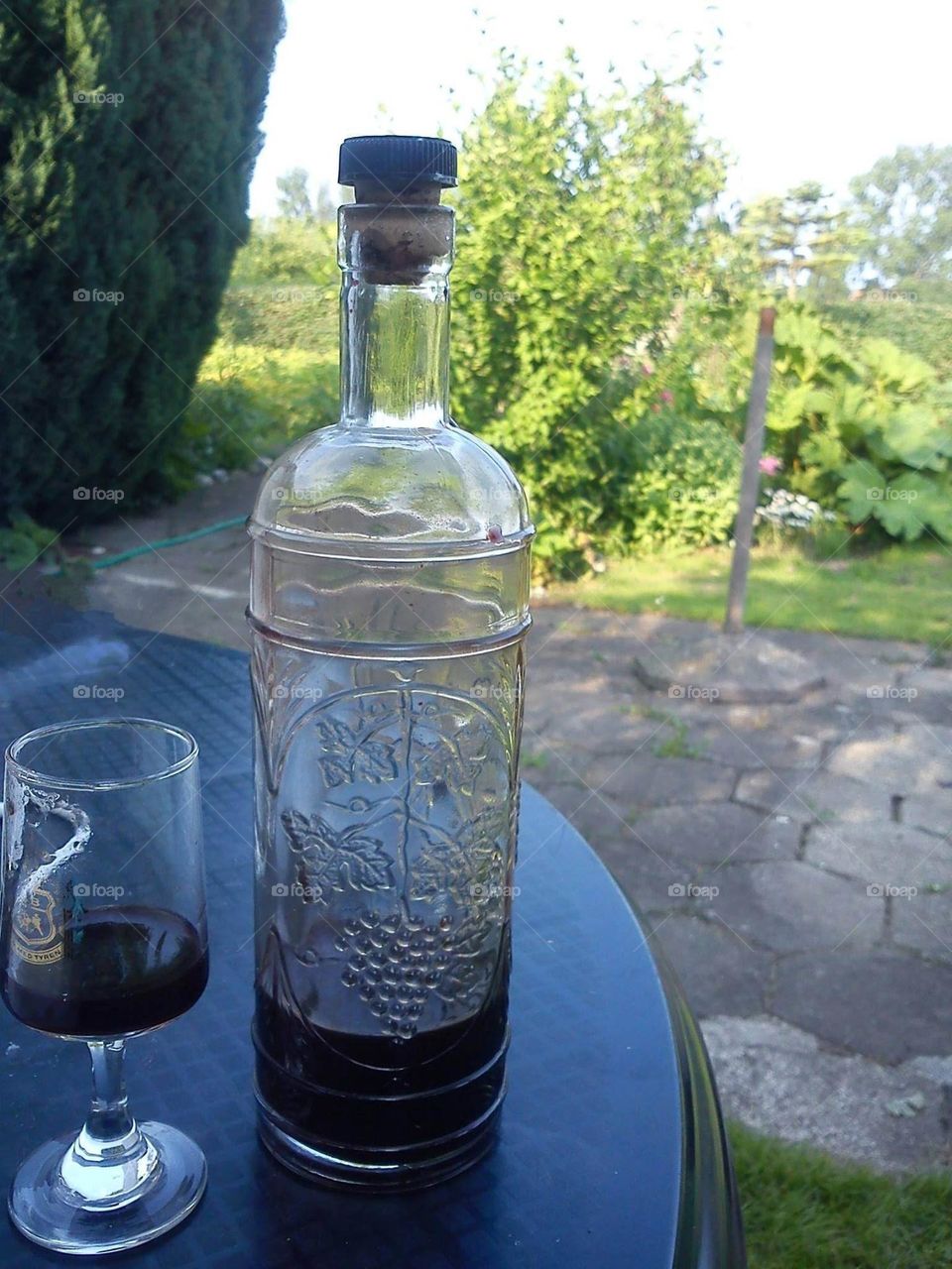 homemade cherry liqueur is enjoyed in the garden