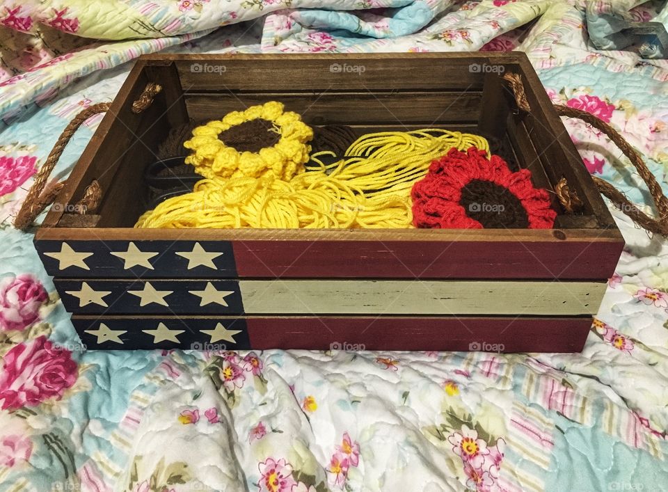 Wood American basket filled with yarn and crochet items 