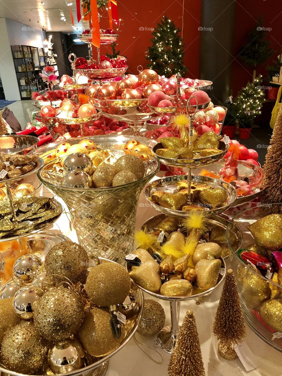 Golden and red Christmas ornaments and glass balls at a Christmas market stand 